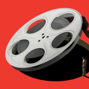 An illustration of a giant film reel being lifted up by an invisible force, revealing a bottomless pit. A man stands on the edge of the deep red floor, peering in as some of the film unspools over him out of frame.