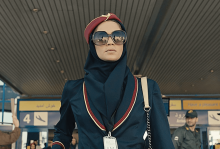 A spy dressed as a flight attendant with sunglasses exits the Tehran airport